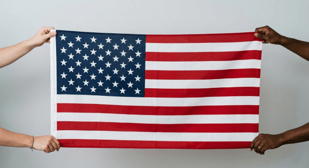 Hands exchanging a neatly folded American flag